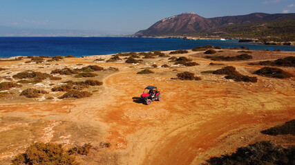 Aerial view of buggy car on the sandy on the sea coast of Cyprus or Greek in summer. Extreme trip off road place. Outdoor adventure for tourists