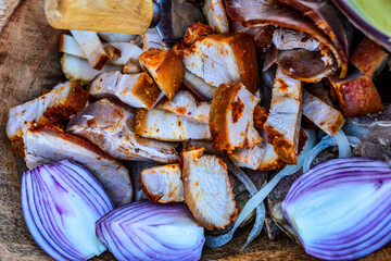 Closeup of the sliced pieces of fried turkey meat with red onions in the bowl