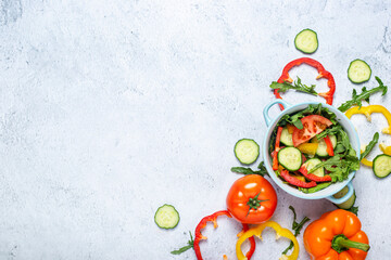 Cooking vegetable salad, vegetables in a blue bowl on a concrete background. Top view, flat lay