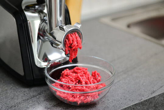 Meat grinder or mincing-machine with mincemeat in. Showing the forcemeat process. Juicy meat climbs out of the meat grinder.