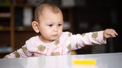 Fototapeta premium Baby Asian Girl drawing and playing as she develops her motor skills