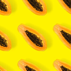 Fresh ripe papaya seamless pattern on yellow background. Tropical abstract background. Top view. Creative design, minimal flat lay concept. Trend tropical fruit food background pattern