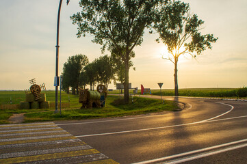 Summer asphalt highway road at sunset with fields on the horizon