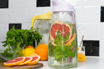 close-up of finely chopped fruit and mint, in a glass jug, in the process of making a drink