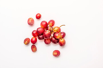 Small bunch of ripe dessert grapes on white background, some split in half