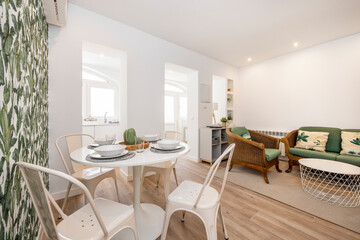Round white dining table with the service set in a bright apartment for vacation rental