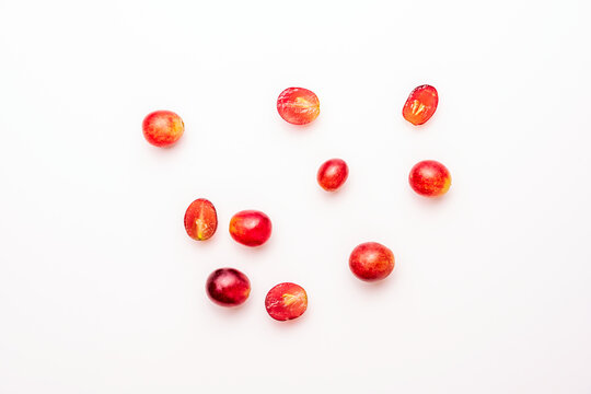 top view image of some claret red dessert grapes on white table