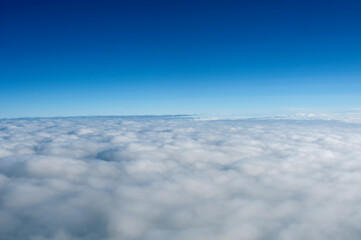 Above view from plane on blue sky and clouds