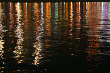 Reflection of the lanterns of the boulevard on the sea. - obrazy, fototapety, plakaty