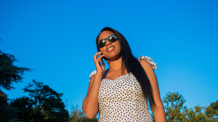 Happy hispanic millennial teenager checking social media with smartphone . A young smiling Latin American girl using a mobile phone app playing games, shopping online.