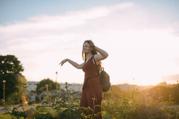 Portrait of a beautiful young woman in the park at sunset in summer.