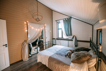 Modern scandi style bedroom interior. Nobody. A small cozy bedroom with a large soft bed