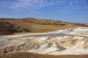 People walk near a mud volcano.