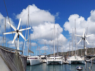 Catamarans and sailboats in the French West Indies marina. Marina in the caribbean under tropical...