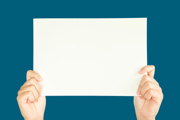 women hand holding white blank paper isolated on blue background with clipping path
