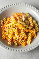 colored pasta in plate on rustic background