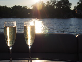 Sunlit Champagne Toast with Sparkling Bubbles Against a Lake Sunset