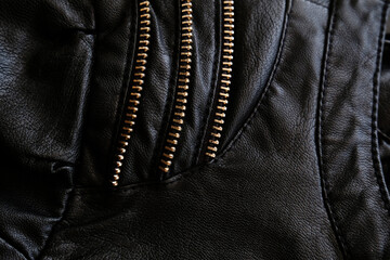 Black leather fabric with zippers, background. Fashion design detail