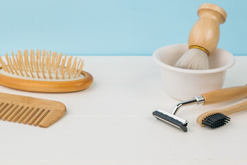 Shaving accessories, a toothbrush and combs on a white table on a blue background.