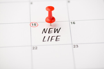 Closeup photo of mark on calendar at fifteenth inscription new life with red pushpin