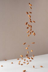 Flying almond nuts. Fresh raw almonds fall on a white background.