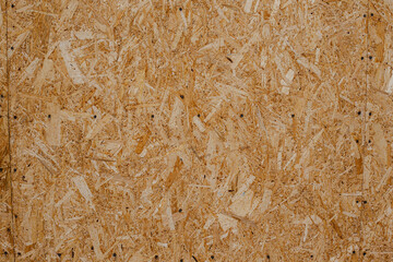 OBS background. Textured background of oriented strand board of light brown color consisted of pressed sawdust 