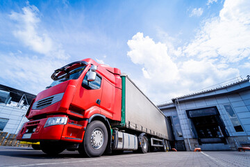 Large trucks near warehouse against blue sky background