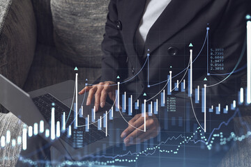Woman typing the keyboard to research stock market to proceed right investment solutions. Internet trading and wealth management concept. Formal wear. Hologram Forex chart over close up shot.