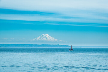 Sailboat on Puget Sound on a blue sky summer day with Mt. Rainier in the background