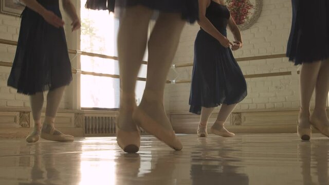 ballerinas training, blue clothes in ballet training, legs close-up, girl stands on pointe shoes.