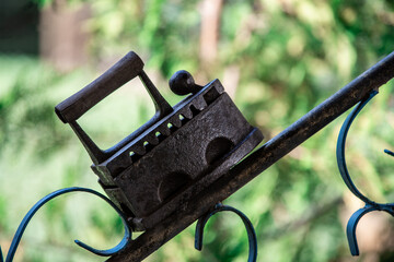 old rusty iron iron on the fence. Close-up