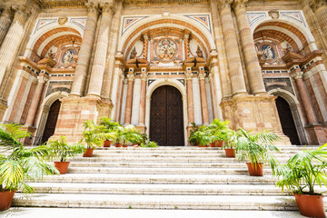 Naklejka premium View on Malaga cathedral entrance with steps decorated with plants
