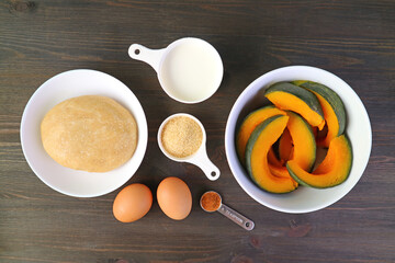 Top View of the Ingredients for Baking Fresh Pumpkin Pie on the Black Wooden Background