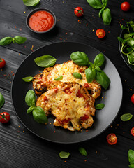 Baked Cauliflower steak with marinara sauce and cheese on plate. Healthy vegetarian food