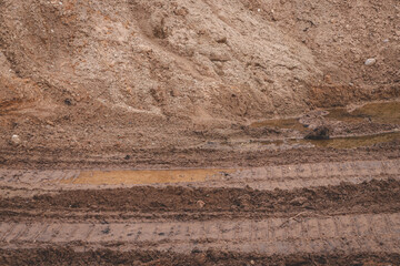 truck or heavy bulldoser or excavator tyre prints in gravel quarry road.	