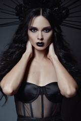 Halloween theme: beautiful young witch. Dark beauty: portrait of seductive goth girl