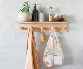 Simple bathroom interior - wooden shelf with a towel, shampoo,  flower. Minimalism style,...