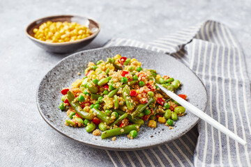 Quinoa salad with green beans, corn, red bell peppers, peas and soybeans. Useful vegetable mix