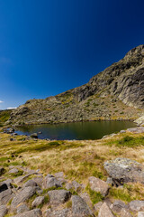 Fototapeta na wymiar A lake in the Peñalara mountains in the Northern Mountain range of Madrid. This part has wonderful hikes starting and panoramic views over the hills and valleys. 