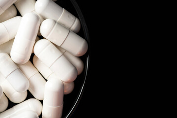 White Medicine Drug Capsules on Black Background Macro Close Up