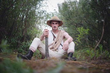Adventurer man with machete knife in the jungle thicket concept. - obrazy, fototapety, plakaty