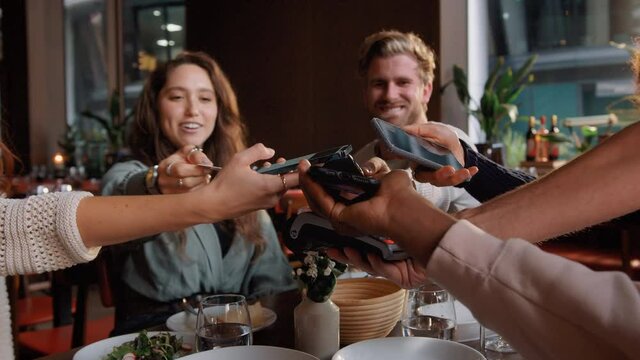 Friends Splitting The Bill In Restaurant