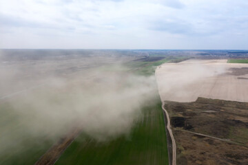 Dust storm on an agricultural field. Drone view
