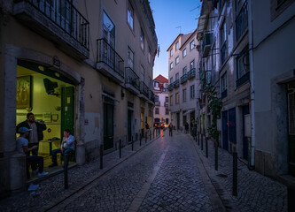 Fototapeta na wymiar Life on the streets of the old city at sunset. Evening in the center of the old city of Lisbon. Alfama. Portugal.