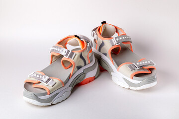 Women's, fashionable, sports sandals with orange accents on a white background. New youth shoes for girls. Front view.