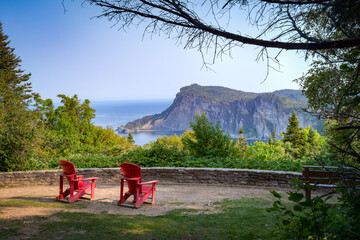 Point of view over Forillon national park at dusk, two empty adirondack chairs, Gaspésie, QC,...
