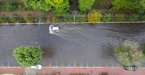 Cars are moving in a heavily flooded street after an abnormal downpour.