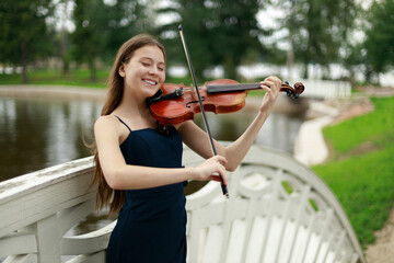 beautiful girl with violin smiling in nature