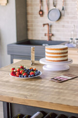 fresh strawberries, blueberries on a white plate, in the kitchen