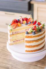 Cake, cut in half, decorated with fresh strawberries, blueberries